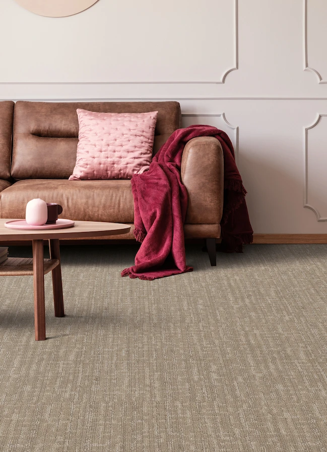 brown textured carpets in a stylish living room with brown leather couch and pink accents